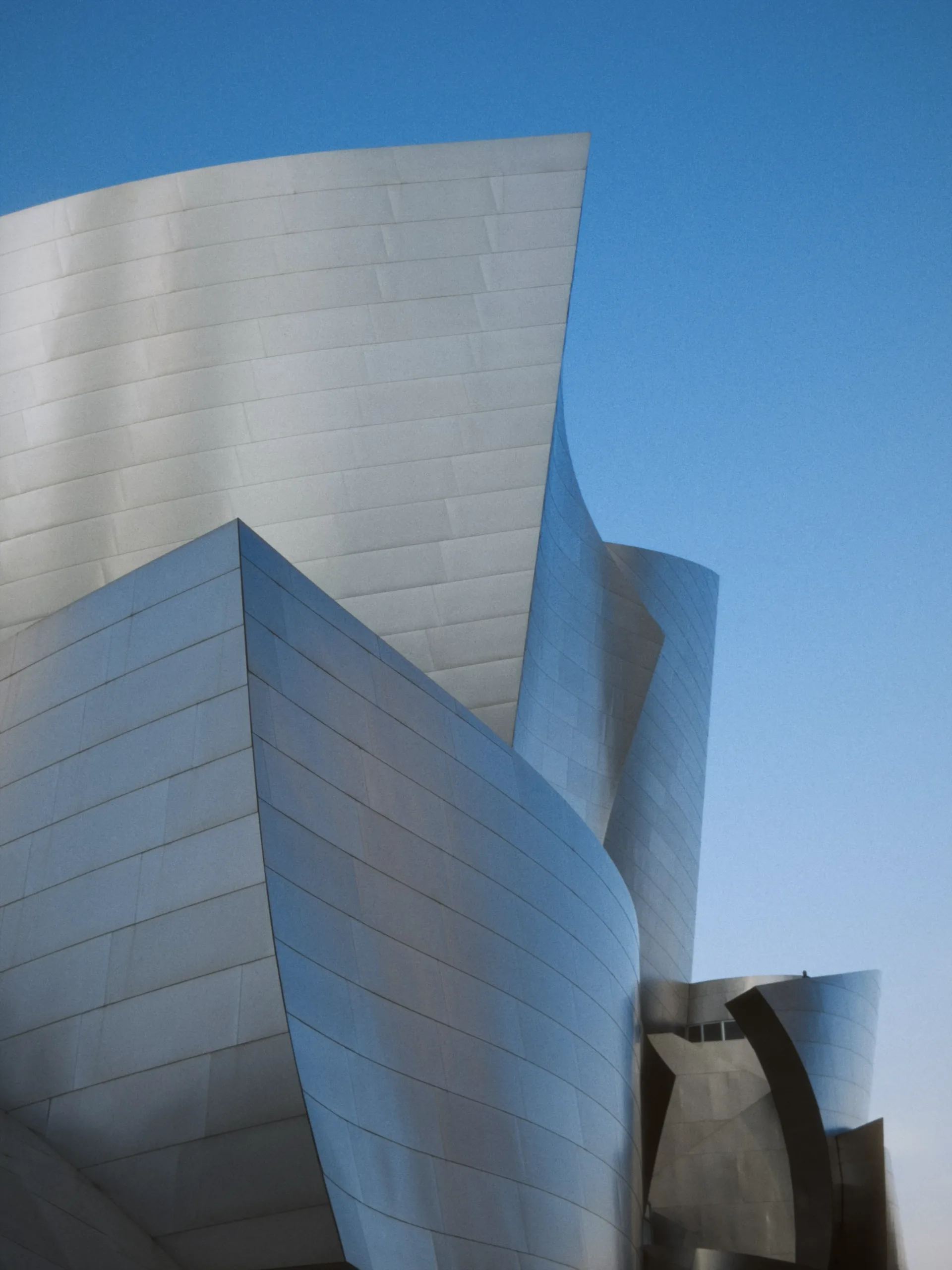 A sculptural silver building against a blue Los Angeles sky.