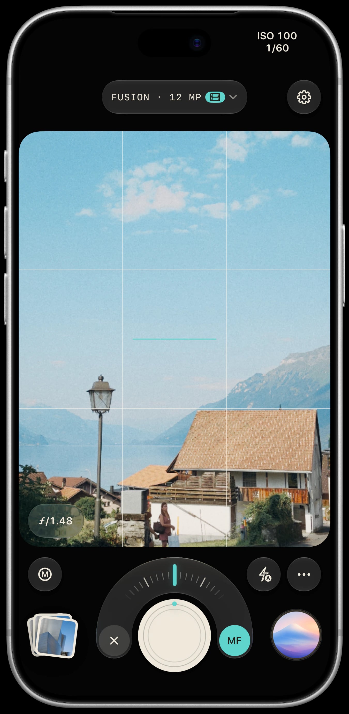 Sundae camera on a silver iPhone 18 Pro, with manual focus active over a Fuji lakeside village preview.